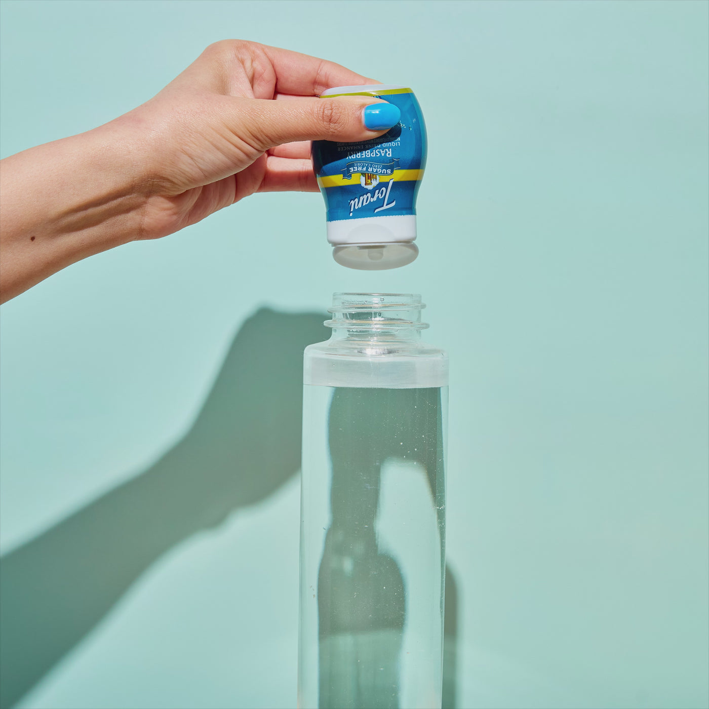 Squeezing Sugar Free Raspberry Liquid Drink Enhancer in a water bottle