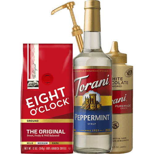 Peppermint Syrup, Puremade White Chocolate Sauce, a bag of Eight O'Clock Coffee Original Ground, and a dispensing pump